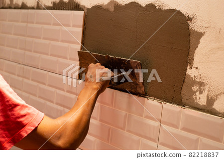 House renovation, laying ceramic tles on the wall 82218837