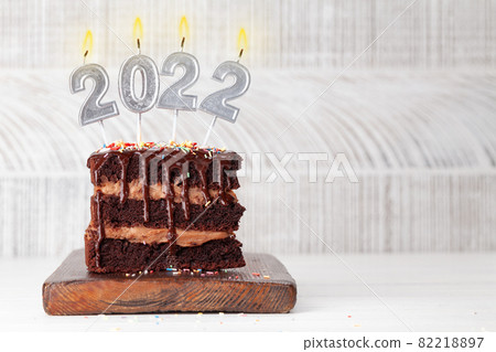 Christmas chocolate cake with number 2022 burning candles 82218897