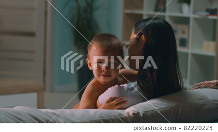 Mother comforting son on sofa Mother comforting son on sofa 82220223