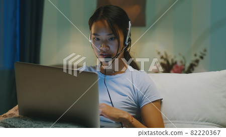Asian mother using laptop for work in evening 82220367