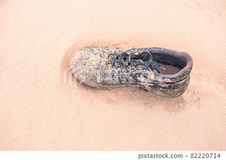 Close Up Of old shoe Weathered On Beach Sand Pollution Litter Rubbish In The Baltic sea Close Up Of old shoe Weathered On Beach Sand Pollution Litter Rubbish In The Baltic sea 82220714
