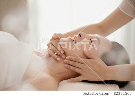 Middle-aged woman receiving a massage at an esthetic salon 82221503