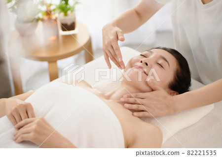 Middle-aged woman receiving a massage at an esthetic salon 82221535