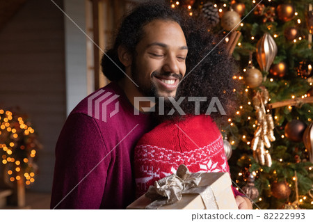 Happy biracial couple hug exchange gifts on Christmas Happy biracial couple hug exchange gifts on Christmas 82222993