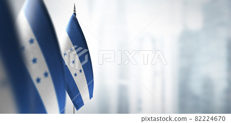 Small flags of Honduras on a blurry background of the city Small flags of Honduras on a blurry background of the city 82224670