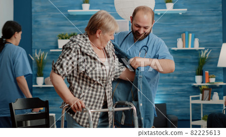 Senior woman with disability receiving help from man nurse Senior woman with disability receiving help from man nurse 82225613