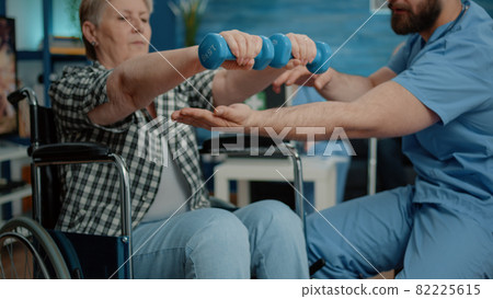 Close up of disabled woman using dumbbells for recovery Close up of disabled woman using dumbbells for recovery 82225615