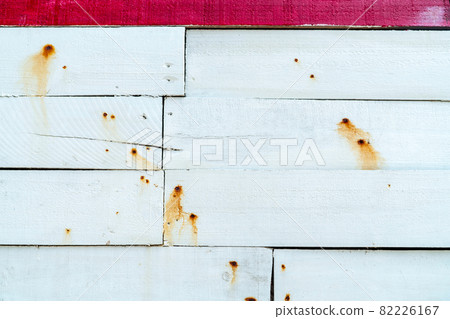 White wooden wall texture background. Wood plank surface texture background. Timber wooden wall texture background. Exterior design. The orange color of rusty nails stains on a white wooden wall. 82226167