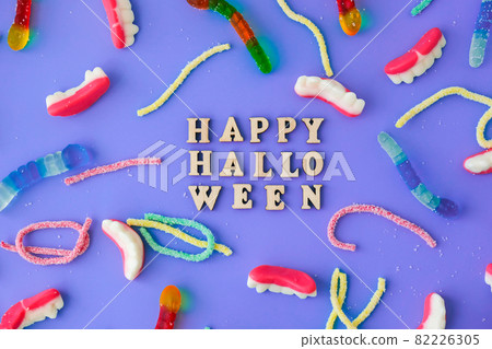 Halloween concept. Halloween party decorations with words Happy Halloween, sweets, top view flat lay on blue background Halloween concept. Halloween party decorations with words Happy Halloween, sweets, top view flat lay on blue background 82226305