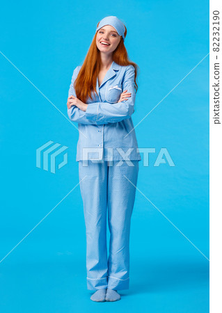Lifestyle, people concept. Happy good-looking glamour redhead european female in nightwear and sleep mask, cross arms chest and smiling delighted, feeling energized morning 82232190