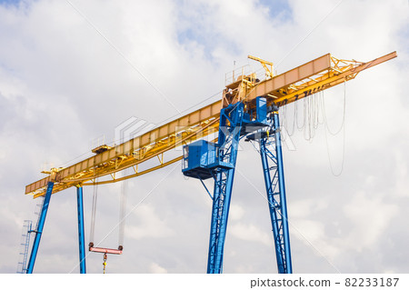 Overhead industrial crane at a construction site against the background of the sky Overhead industrial crane at a construction site against the background of the sky 82233187