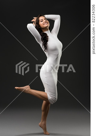 Slender woman in white dress in studio Slender woman in white dress in studio 82234306
