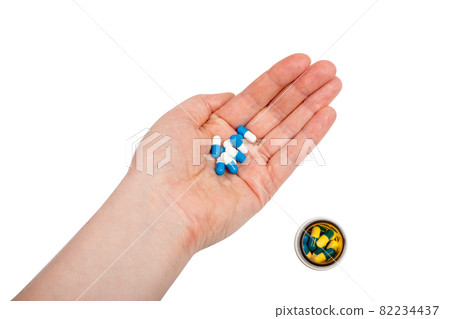 Blue capsule pills in hand isolated 82234437