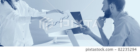 Side view of two employees working together in he office. Financial graph. Career concept. Duotone effect 82235294