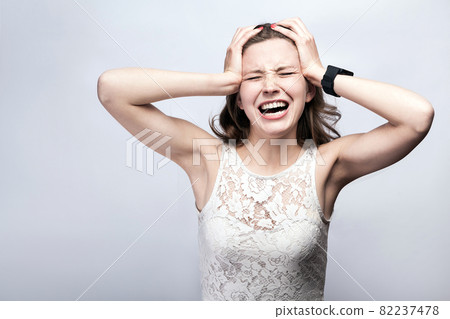 woman with freckles and white dress and smart watch with headache pain on silver gray background. 82237478
