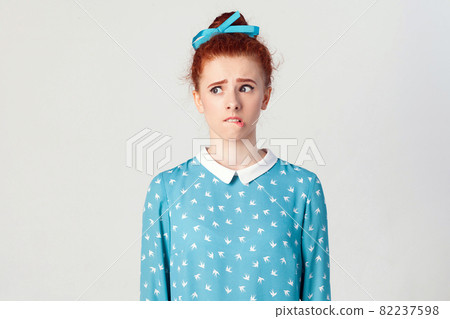 girl doubtful and indecisive face expression, pursuing her lips as if forbidden to say anything. 82237598