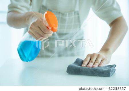 Housewife sanitizing on a surface. 82238857