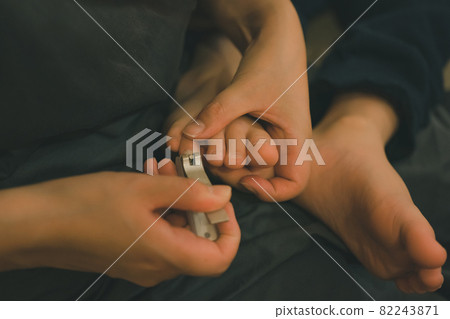 Mother cutting a child's toenails Mother cutting a child's toenails 82243871