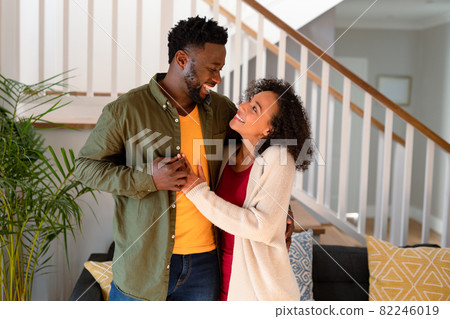 Happy african american couple hugging and looking at camera Happy african american couple hugging and looking at camera 82246019