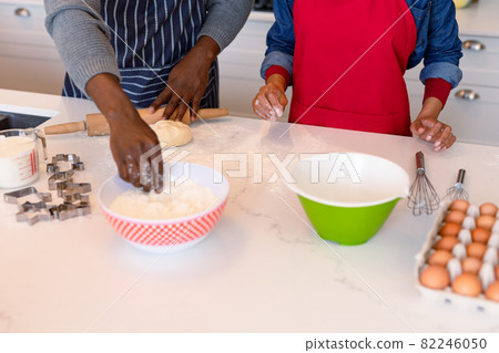 Midsection of african american couple wearing aprons, baking together Midsection of african american couple wearing aprons, baking together 82246050