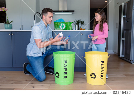 Happy caucasian father and daughter segregating rubbish Happy caucasian father and daughter segregating rubbish 82246423