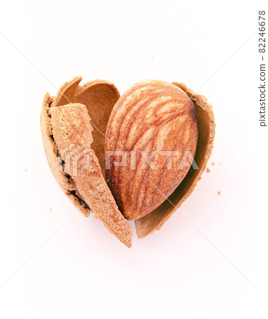 Close up almonds nut shell cracked in heart shape isolated on white background. Love healthy eating concept. Close up almonds nut shell cracked in heart shape isolated on white background. Love healthy eating concept. 82246678