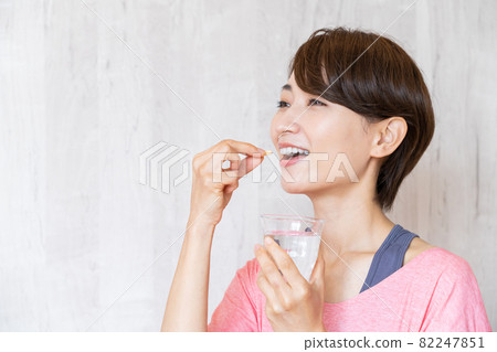 Middle women drinking supplements 82247851
