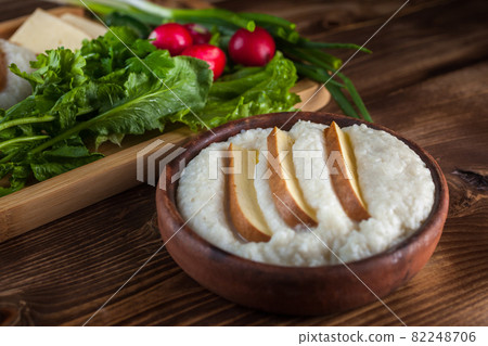 Mengrelian corn mamalica (ghomi) with cheese and various herb on wooden table. Georgian traditional food Mengrelian corn mamalica (ghomi) with cheese and various herb on wooden table. Georgian traditional food 82248706