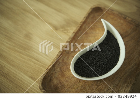 black sesame seeds on a white plate. Wooden table. Soft selective blurred background black sesame seeds on a white plate. Wooden table. Soft selective blurred background 82249924