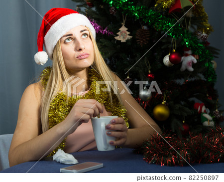 Girl is bored and drinking tea in New Year night 82250897