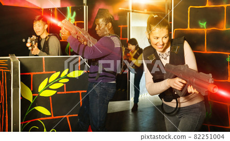 Young man and woman playing laser tag 82251004