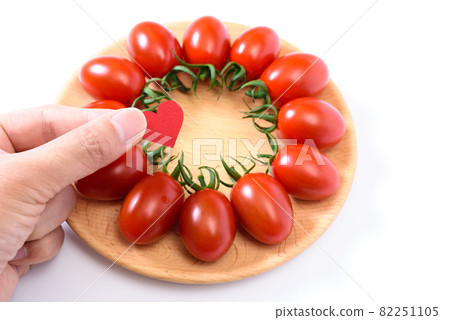 Mini tomatoes arranged neatly on a wooden plate Hand with a heart Aiko Mini tomatoes arranged neatly on a wooden plate Hand with a heart Aiko 82251105
