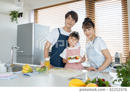 Elementary school girl, dad and mom making lunch in the kitchen 82252876