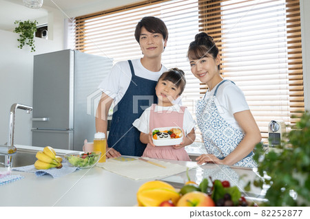 Elementary school girl, dad and mom making lunch in the kitchen 82252877