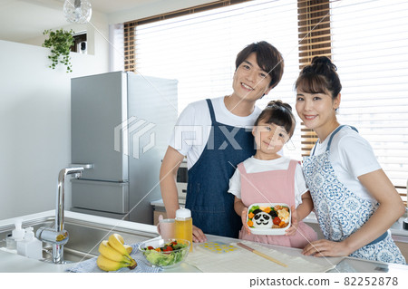 Elementary school girl, dad and mom making lunch in the kitchen Elementary school girl, dad and mom making lunch in the kitchen 82252878