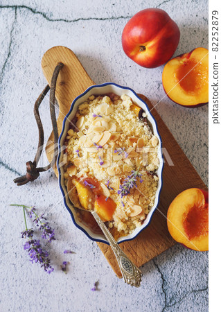 Summer dessert. Fresh peach crumble, almonds petal and lavender 82252879
