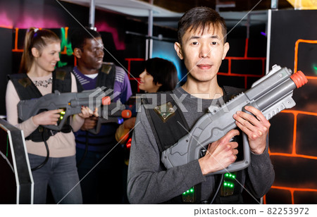 Asian man with laser gun ready for lasertag game Asian man with laser gun ready for lasertag game 82253972