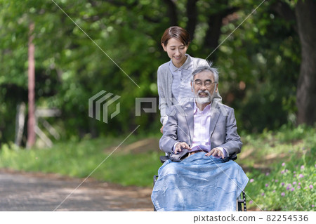 在公園散步的老年人和看護者 在公園散步的老年人和看護者 82254536