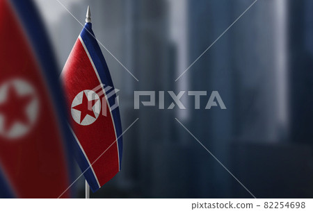 Small flags of North Korea on a blurry background of the city Small flags of North Korea on a blurry background of the city 82254698