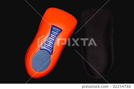 The orthopedic insole on a black background. The orthopedic insole on a black background. 82254788