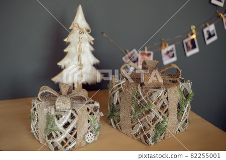 Christmas gift boxes on the table surface with white decorative xmas tree and garland Christmas gift boxes on the table surface with white decorative xmas tree and garland 82255001