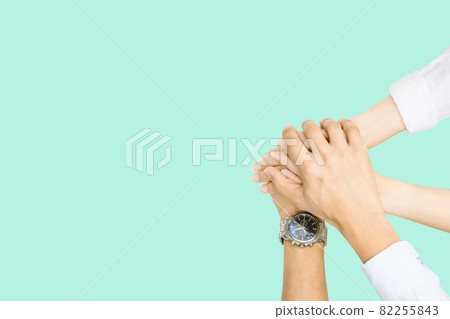 Hands clasped in collaboration top view of individuals bringing their hands together to signify unity and teamwork Hands clasped in collaboration top view of individuals bringing their hands together to signify unity and teamwork 82255843