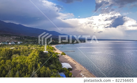 Idyllic summer landscape with lake near mountain with reflection from clouds and forest. Issyk kul, Kyrgyzstan. 82256605