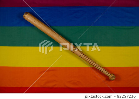 Wooden baseball bat with original design on LGBT rainbow flag background. The symbol of love and tolerance versus the symbol of hatred and intolerance. LGBT Pride Month. Close Up. Top view Wooden baseball bat with original design on LGBT rainbow flag background. The symbol of love and tolerance versus the symbol of hatred and intolerance. LGBT Pride Month. Close Up. Top view 82257230