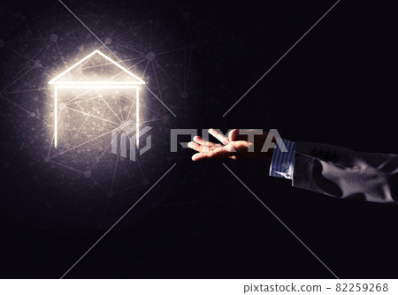 Conceptual image with hand pointing at house or main page icon on dark background Conceptual image with hand pointing at house or main page icon on dark background 82259268
