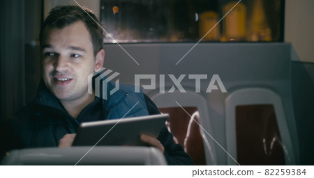 Smiling man in the bus with tablet computer Smiling man in the bus with tablet computer 82259384