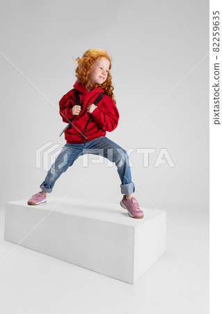 Portrait of little smiling girl, child posing isolated over gray studio background. Happy childhood Portrait of little smiling girl, child posing isolated over gray studio background. Happy childhood 82259635