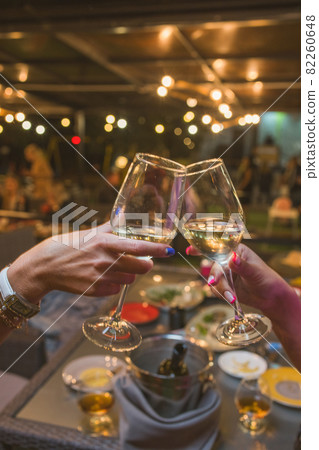 Celebration. People holding glasses of white wine making a toast. Celebration. People holding glasses of white wine making a toast. 82260648