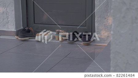 Woman putting on shoes by the house Woman putting on shoes by the house 82261484