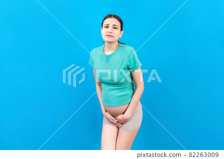 urinary incontinence during pregnancy. Abdominal pain during pregnancy. Maternity healthcare concept on colored background urinary incontinence during pregnancy. Abdominal pain during pregnancy. Maternity healthcare concept on colored background 82263009